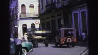 Brazil (1967): Two Old Carts Going Down A Road And A Man Putting Out Fruit At A