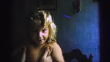 Brazil (1967): A Young Child With Blond Curly Hair Smiling As They Are Being Held