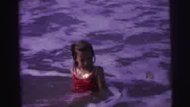 BRAZIL-1967: Young Girl In Red Swimsuit Playing In Ocean Waves