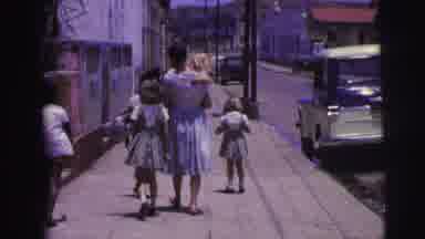 Brazil (1967): Woman Holding Baby Walks The Children Down The Street On A Sunny