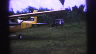Brazil (1967): Man Drives Up To An Airplane In A Land Rover While A Man And Woman