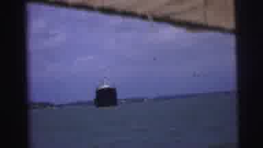 Brazil (1967): Asian Man Wearing A Hat Boating Steering Past A Large Ship On The