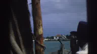 Brazil (1967): Man Smokes On A Boat And Footage Changes To A Village Settlement