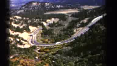 Colorado US (1967): A Big Bus Driving Up A Steep Road Near The Mountains