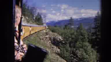 Colorado USA (1967): People Riding On Train Looking Down Side Of Mountain At Trees