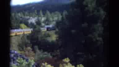 Colorado USA (1967): Train Slowly Moving Next To A Winding Blue River Below The