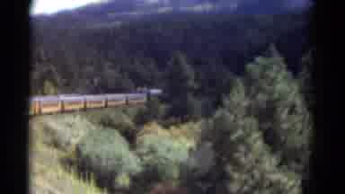 Colorado USA (1967): Train Drives By On The Tracks That Sit Uptop The Bridge The