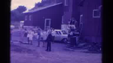 Colorado USA (1967): Person Riding By Red Barn Bar-B-Q With Car And People