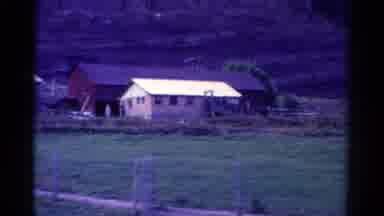 Colorado USA (1967): Passing A Bridge With Houses And Mountains Far Away With
