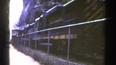 Colorado USA (1967): A Train On Tracks By A Fence Passes Swiftly By