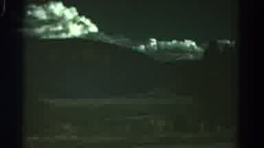 Colorado USA (1967): Trees Pass Behind Road Markers Under White Clouds At Night