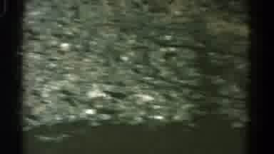 Colorado USA (1967): Man Drives By Rocky Hillside In Bus Behind A Truck In