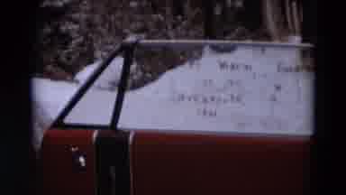 Detriot Michigan-1967: A Person Cleaning A Red Car Window With Snow Behind