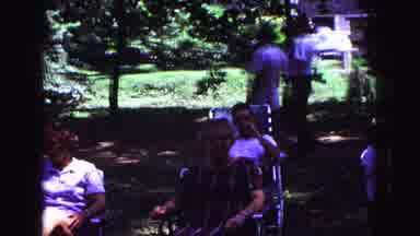 Galena Illinois USA (1967): Man Blows Up Balloon For A Child Outside In The Forest