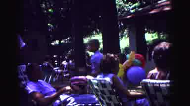 Galena Illinois USA (1967): Adults Sit Down Outside On Deck Chairs While A Child