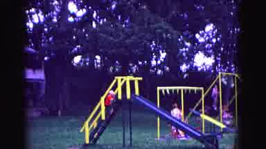Galena Illinois USA (1967): Children Swinging On Swings At A Park As A Little Boy