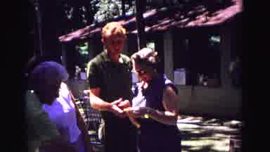 Galena Illinois USA (1967): A Woman Opens A Gift At An Outdoor Party With Family
