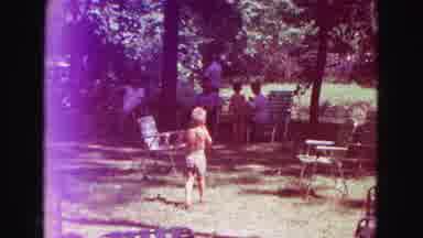 Galena Illinois USA (1967): Man Carries Baby Through Campsite Past Some Trees On A