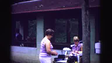 Galena Illinois USA (1967): Man In Lawn Chair Reads While Child And Woman Start