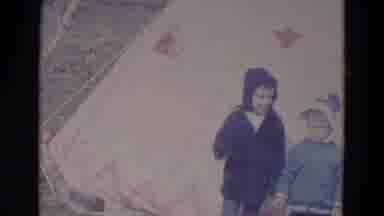 Lincoln Nebraska (1967): Three Kids Wearing Jackets Are Waving In Front Of An