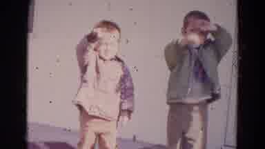 Lincoln Nebraska (1967): Two Little Boys In Coats Standing In The Sun Shield Their