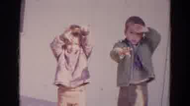 Lincoln Nebraska (1967): Two Small Kids Wearing Jackets And Pants Waving At The