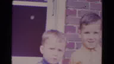 Lincoln Nebraska (1967): Two Boys Stand In Front Of The Door Of A Brick Home And