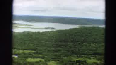 Minnesota US (1967): A Plane Flying Over A Lot Of Trees And Water Spot