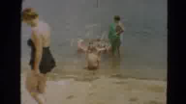 Minnesota US (1967): Children Playing On Green Blow Up Floats In The Ocean Close