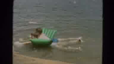 Minnesota US (1967): Two Children Playing In Water On An Inflatable Toy