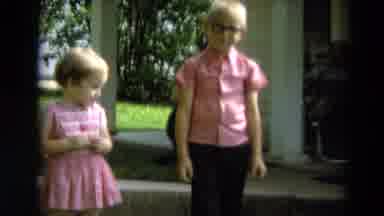 Minnesota USA (1967): Children Dressed In Pink Stand In A Yard With People Behind