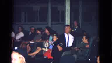 New Mexico USA (1967): Many People Gathered Talking In A Large White Wall Room