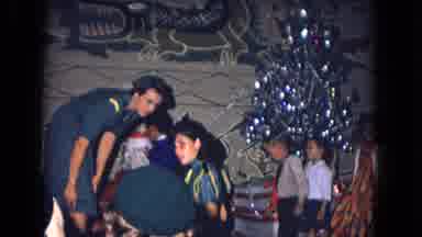 New Mexico USA (1967): Children In A Room Decorated With A Christmas Tree Queuing