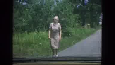 New Mexico USA (1967): Old Woman Walks Up Driveway Towards The Camera And In Front