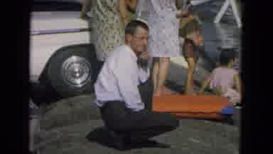 New Mexico USA (1967): Man On Beach With Family While Lady In Bathing Suit Puts On