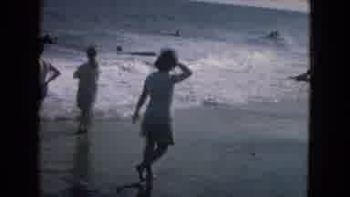 New Mexico USA (1967): A Woman Walks Along The Coast Of A Littered Beach As