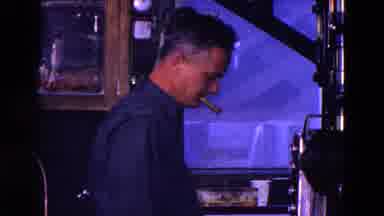 Trenton New Jersey (1967): Man Smoking A Cigar While Setting Up Movie Projector