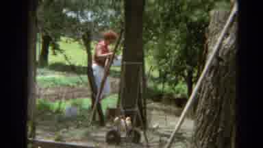 Branson Missouri USA (1968): A Woman Climbs Over A Wire Fence Holding A Container