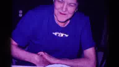 Minnesota USA (1968): Older Woman In A Blue Shirt Sitting At A Dining Room Table