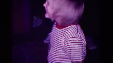 Minnesota USA (1968): A Little Boy Smiling To The Camera While Someone Walks In