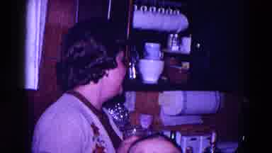 Minnesota USA (1968): Woman Wearing A Sweater Watches A Boy Pour A Drink