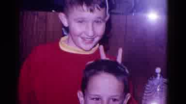 Minnesota USA (1968): Young Boy Holds Up Peace Sign Behind Younger Boy's Head