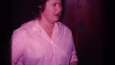 Minnesota USA (1968): A Woman In A Room With Dark Paneling Talks While Children