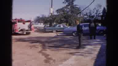 Wauconda Illinois USA (1968): People Stand Around Cars And A Fire Truck Passes By