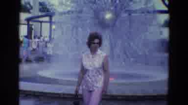 Diller Nebraska (1969): Woman Walking Near A Fountain Followed By An Elevated Lift