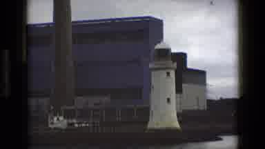 England (1969): A Lighthouse On Shore And A Sweeping View Of Open Waves