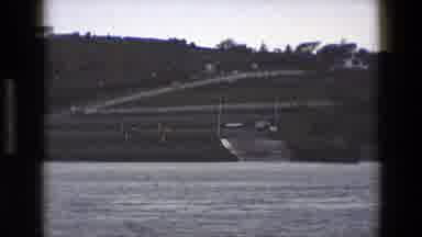 England (1969): A Busy Exit Ramp Near Large Body Of Water In 1960s England