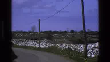 ENGLAND-1969: Stone Wall Next to Road with Power Lines Overhead Across Field