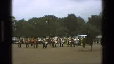 England (1969): Marching Band Percussion Section Being Led By Men On Horseback