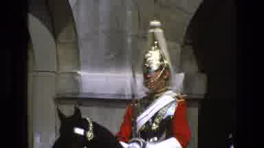England (1969): A Collection Of Royal Guards Sit Atop Horses In A Courtyard